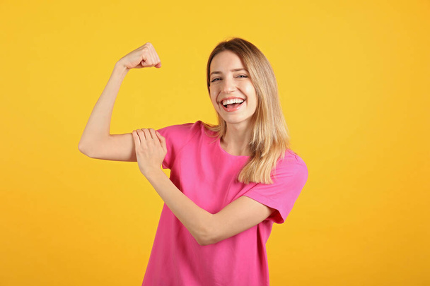 Strong woman as symbol of girl power on yellow background. 8 March concept - Foto, imagen