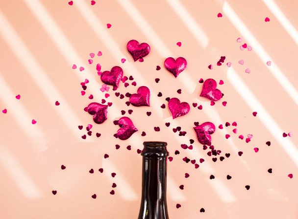 Bottle of wine and pink hearts over morning shadow overlay. - Φωτογραφία, εικόνα