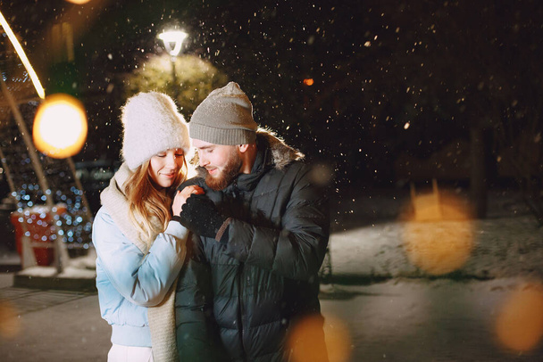 Young couple outdoor in night street at christmas time - Foto, imagen
