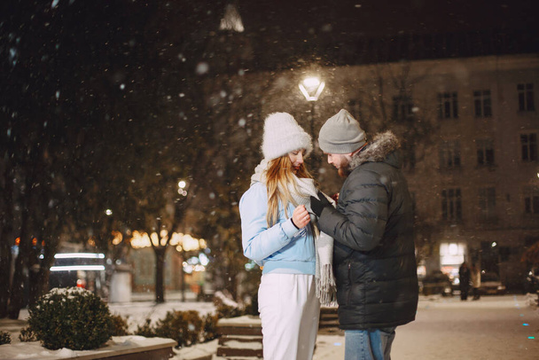 Young couple outdoor in night street at christmas time - Foto, imagen