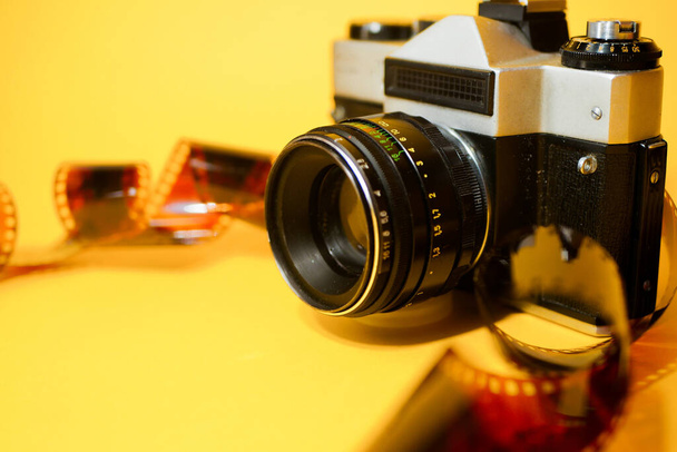 Αναλογική κάμερα με φιλμ 35mm. Κίτρινο φόντο. Φωτογραφία χόμπι - Φωτογραφία, εικόνα