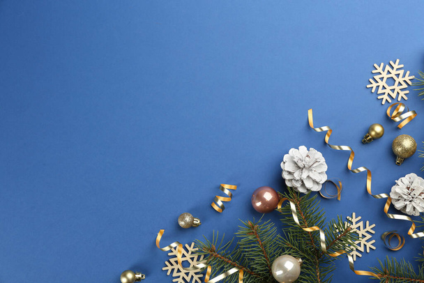 Flat lay composition with serpentine streamers and Christmas decor on blue background. Space for text - Foto, afbeelding