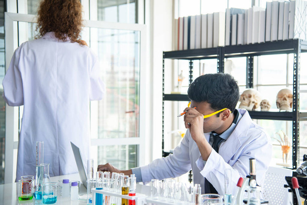 Молоді вчені або дослідники носять окуляри, які проводять дослідження в лабораторії. Вчений працює над комп'ютерним та лабораторним обладнанням
. - Фото, зображення