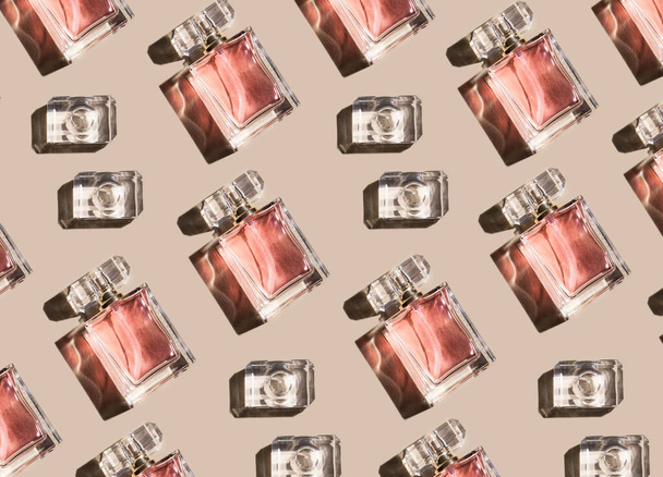 Wzór kobiecych perfum na pastelowym beżowym tle, widok z góry, płaska pościel. Makijaż butelek perfum zapachowych - Zdjęcie, obraz