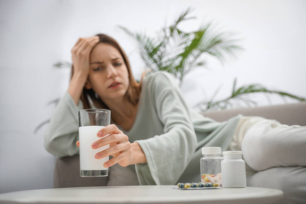 Woman taking medicine for hangover at home, focus on hand - Fotografie, Obrázek