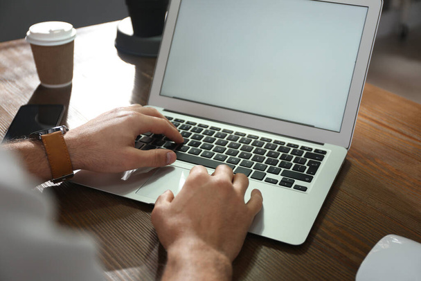 Freelancer working on laptop at table indoors, closeup - Zdjęcie, obraz