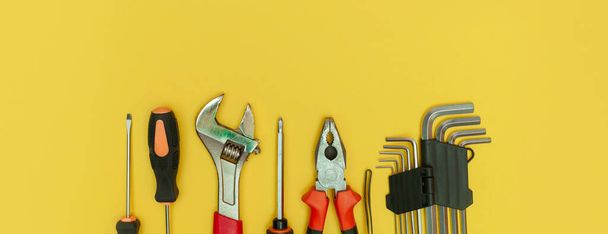 tools on isolated yellow background panorama - Foto, imagen