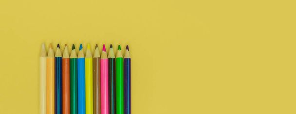 lápis coloridos em um fundo panorâmico amarelo - Foto, Imagem