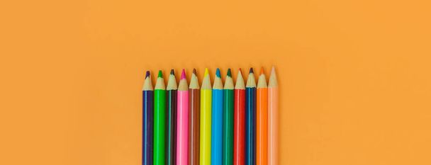 lápices de colores sobre un fondo panorámico amarillo - Foto, Imagen