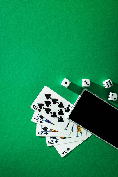 kártyázás póker kocka és telefon zöld kék ruhán - Fotó, kép