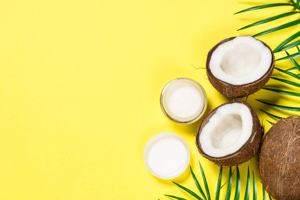 Palmové listy a kokosový ořech na žlutém výhledu. - Fotografie, Obrázek