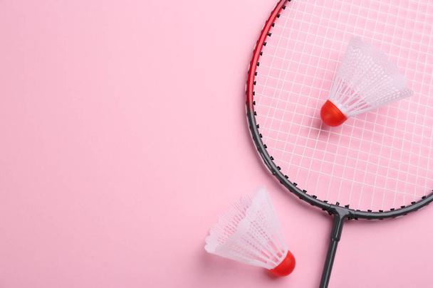 Badminton racket and shuttlecocks on pink background, flat lay. Space for text - Фото, изображение