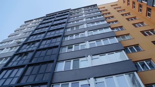 Nowy nowoczesny budynek mieszkalny w kraju Związku Radzieckiego. Budynek mieszkalny na zewnątrz z elewacją żółtego domu i małymi balkonami - Materiał filmowy, wideo