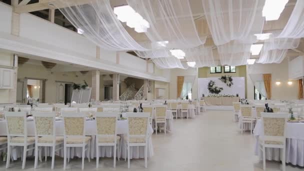 Interior de una decoración de salón de bodas listo para los invitados. Mesas en el banquete de bodas. Decoraciones de boda. Decoración de la boda en la sala de banquetes. - Metraje, vídeo