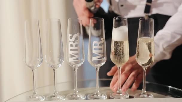 Официант наливает шампанское в бокалы на свадьбу - Кадры, видео