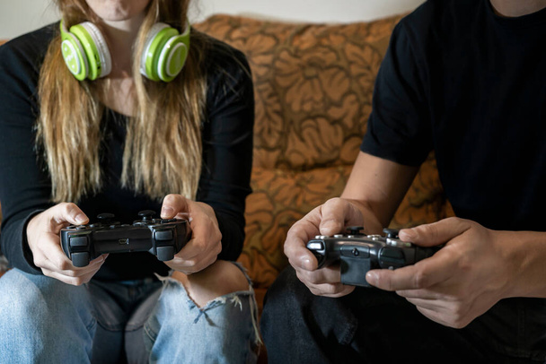 Couple playing video games at home. Playful people ,gaming lifestyle, friends having fun together concept. - Photo, image