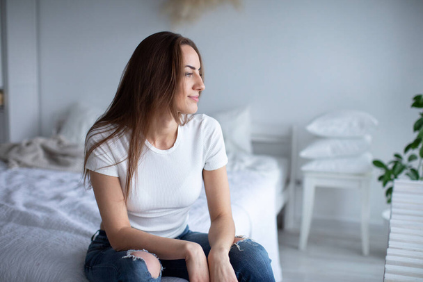 Smiling young woman wearing casual clothes while relaxing at home. - 写真・画像
