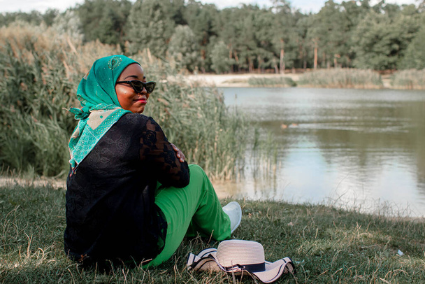 African Woman In Muslim Clothes Near Lake Enjoys The Beautiful Nature - Foto, Imagem
