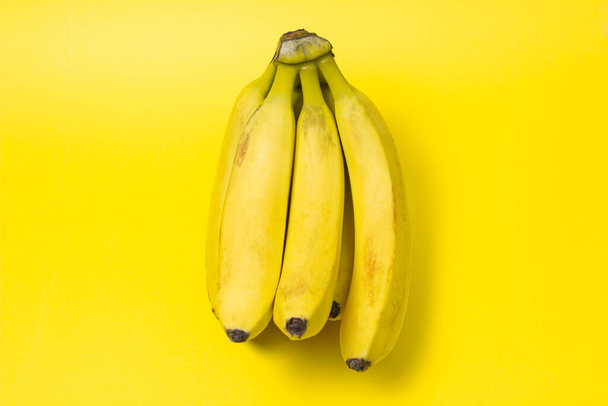 Banány na žlutém pozadí. Čerstvé žluté banány. Banánová parta. Exotické ovoce - Fotografie, Obrázek