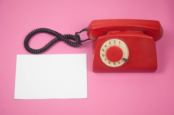 Teléfono giratorio rojo retro sobre fondo rosa, estilo vintage  - Foto, Imagen