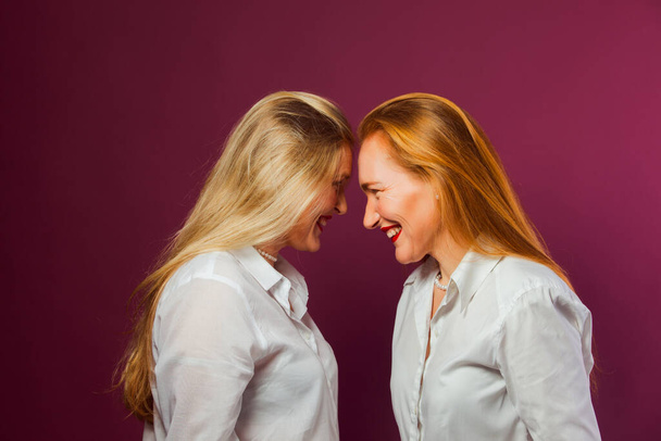 Dwie kobiety stojące naprzeciwko siebie, dotykające się głowami - Zdjęcie, obraz