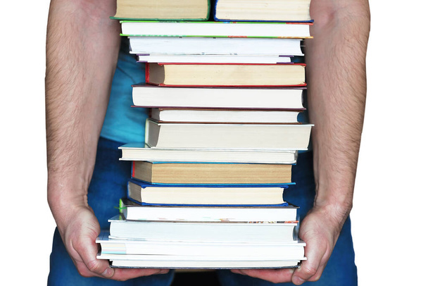 Es una pila de libros en manos de un hombre, aislados sobre un fondo blanco. El concepto de educación  - Foto, imagen