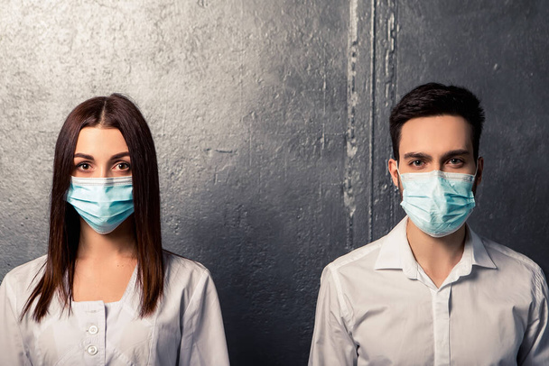 Doctor nurse patient in personal protective equipment. Healthcare concept. Couple wear white shirt medical gown, blue face disposable mask. Coronavirus pandemic. Epidemic disease. - Foto, imagen