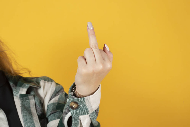 mano donna con le dita gesto osceno, sfondo giallo, spazio copia - Foto, immagini