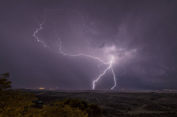 Beautiful night sky with lightning and thunderbolts during a thunderstorm in the countryside - Photo, Image
