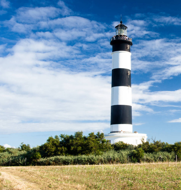 Lighthouse with blue sky and summer clouds in chassiron, Oleron Island, France - Photo, Image