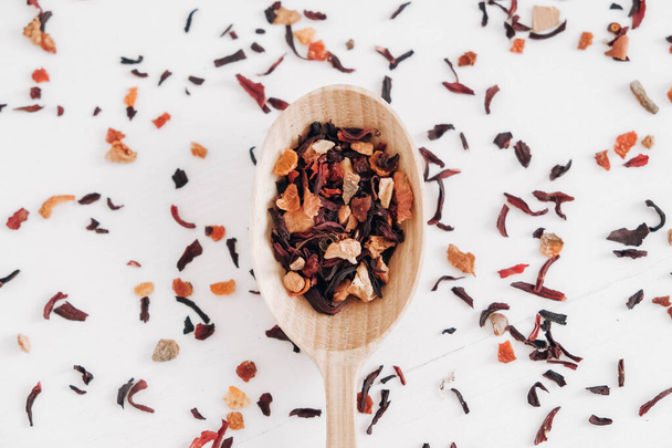 Dry fruit tea in a wooden spoon scattered on a white background. Top view. Copy, empty space for text. - 写真・画像