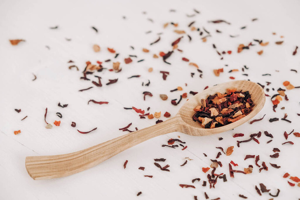 Dry fruit tea in a wooden spoon scattered on a white background. Top view. Copy, empty space for text. - Fotoğraf, Görsel
