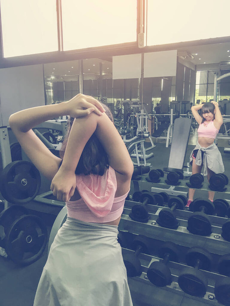Asian teenage girls are warm up before exercise in the gym. - Photo, Image