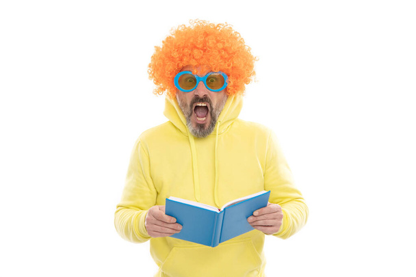 Geeky bibliofil w funky peruka zachować usta otwarte czytanie książki szkolnej, biblioteka. - Zdjęcie, obraz