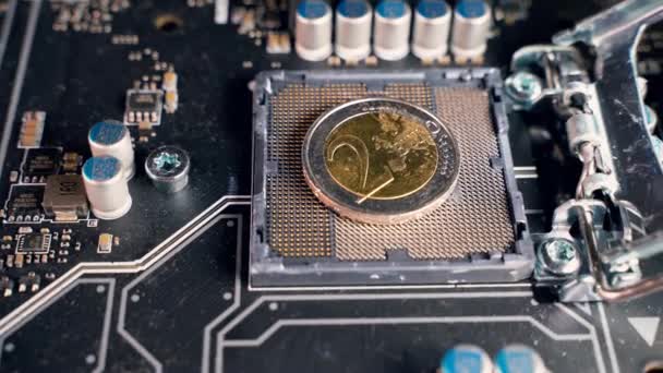 2-Euro-Münze über einem CPU-Schlitz in einer Hauptplatine, symbolisiert den digitalen Euro. - Filmmaterial, Video