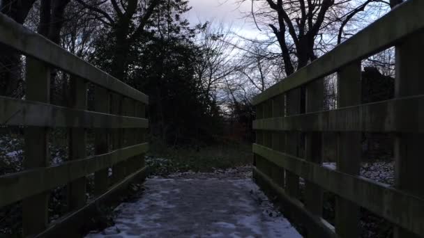Rickety wooden bridge covered in snow and ice in winter - Footage, Video