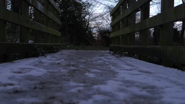  Rickety ξύλινη γέφυρα καλυμμένη με χιόνι και πάγο το χειμώνα - Πλάνα, βίντεο