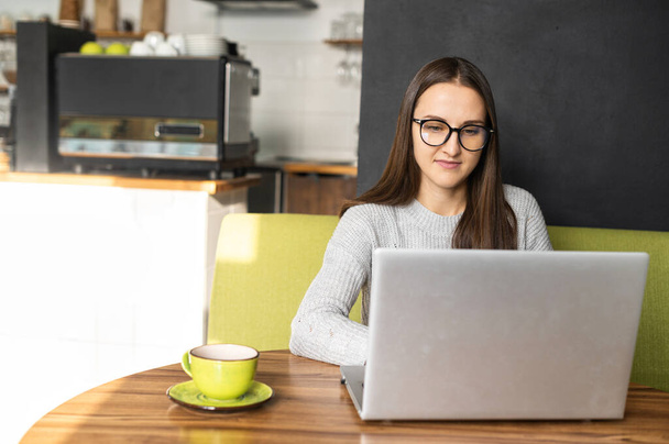 Jeune femme avec un ordinateur portable dans le café - Photo, image