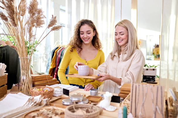 two women buying kitchen items, mug in zero waste shop - Foto, Bild
