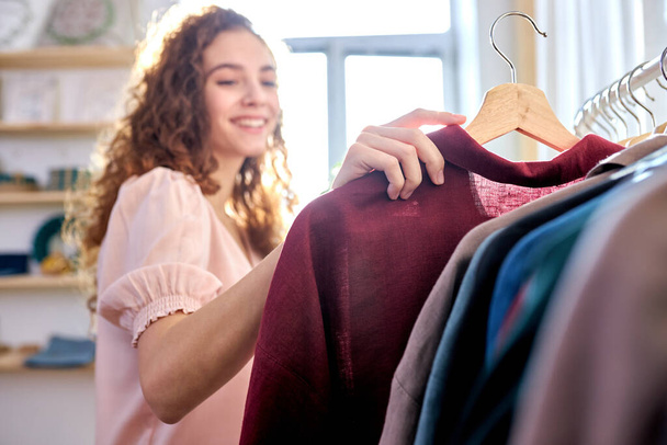 positive attractive young women in an ecological shop choosing between various clothes - Fotografie, Obrázek
