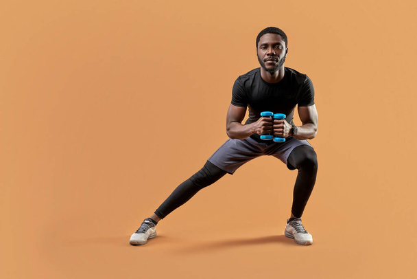 fit man lunges with dumbbells in hands - Foto, afbeelding