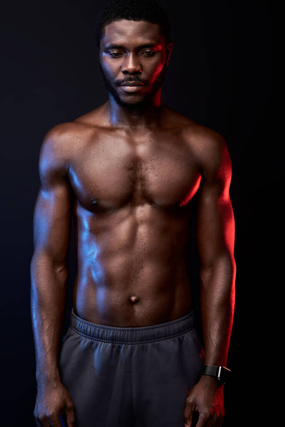feel fit. young muscular african american man with naked torso posing at camera while posing shirtless - Foto, Imagen