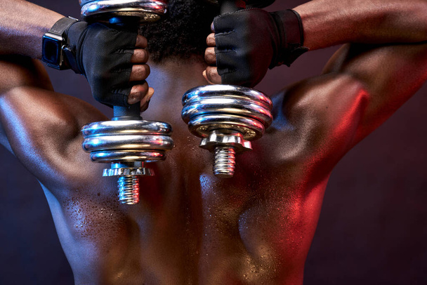 rear view on black bodybuilder man with dumbbells - Fotografie, Obrázek