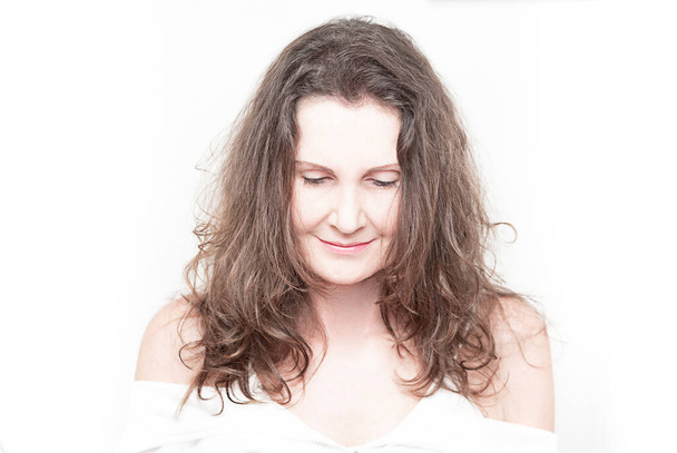 Πορτρέτο της καυκάσιας γυναίκας με μακριά σκούρα καστανά μαλλιά σε λευκό φόντο. Υπερεκτιθέμενη καλοκαιρινή φωτογραφία.  - Φωτογραφία, εικόνα