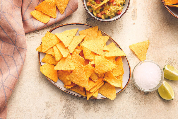 Lemez ízletes nachos és mártással, könnyű háttérrel - Fotó, kép