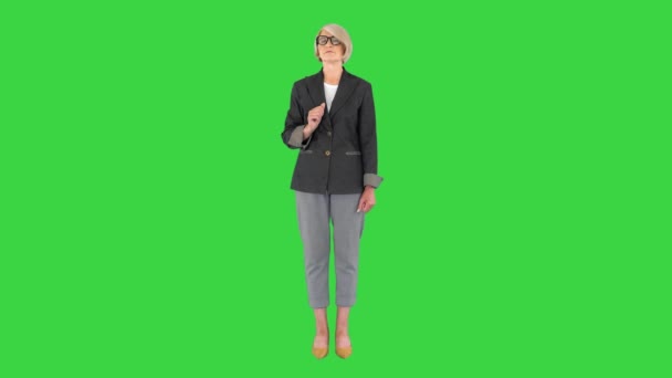 Donna d'affari anziana che indica i lati che presentano qualcosa su uno schermo verde, Chroma Key. - Filmati, video
