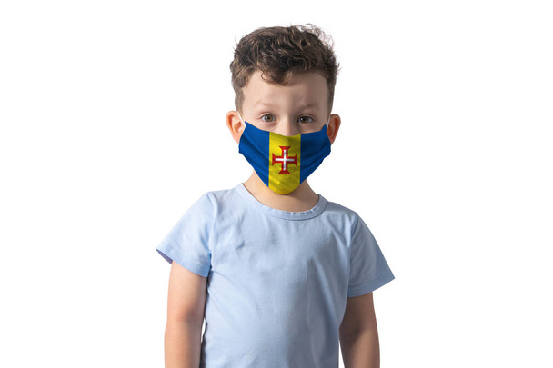 Hengityssuojain Madeiran lipulla. Valkoinen poika laittaa lääketieteen kasvot naamio eristetty valkoisella taustalla. - Valokuva, kuva