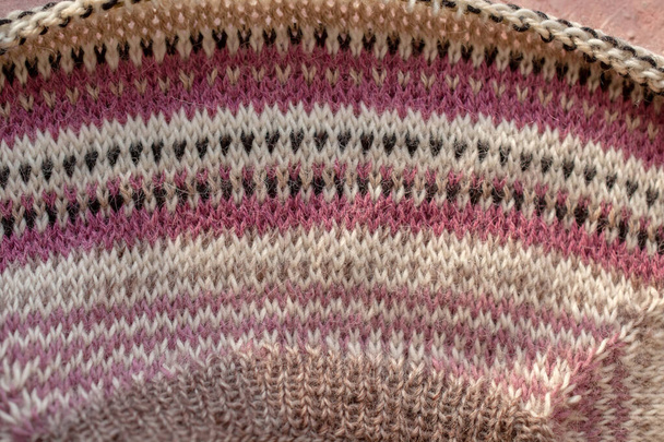 fragmento de suéter raglán de rayas cálidas sobre fondo de hormigón rosa. - Foto, imagen