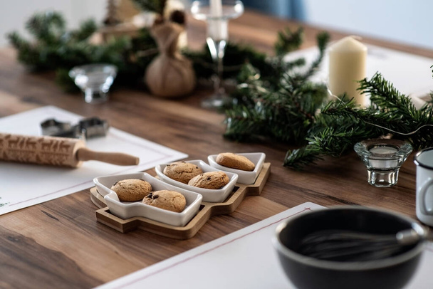 Christmas table decoration. Cookies in a herringbone-shaped plate. Festive atmosphere at home - Foto, imagen