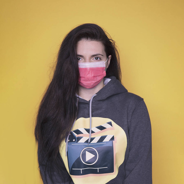 γυναίκα με μάσκα σε κίτρινο φόντο. κοβίδιο 19 - Φωτογραφία, εικόνα